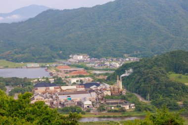 Kırsal dağ manzarasındaki küçük fabrikadan dumanlar yükseliyor. Yüksek kalite fotoğraf