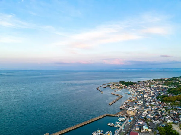 Gün batımından önce küçük kıyı köyünü koruyan dalgaların havadan görünüşü. Yüksek kalite fotoğraf