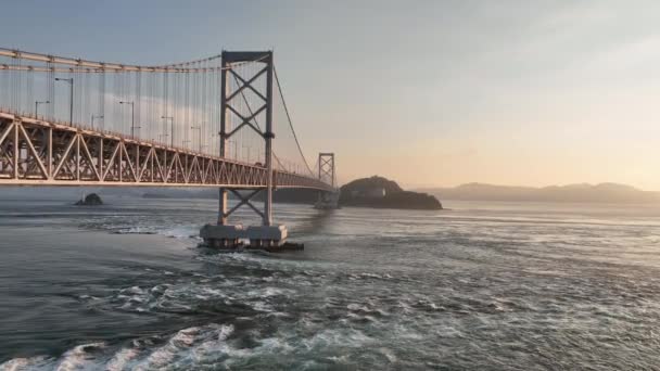 日没時に吊橋の下を高速で動く潮流の上をゆっくりと移動します 高品質4K映像 — ストック動画
