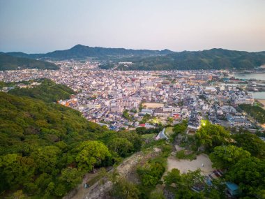 Sabah erkenden yeşil tepeler arasında küçük bir kasaba vadiye yayıldı. Yüksek kalite fotoğraf