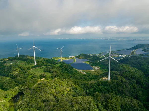 Rüzgâr türbinleri ve güneş panelleri. Bulutların arasından bir parça güneş geçiyor. Yüksek kalite fotoğraf