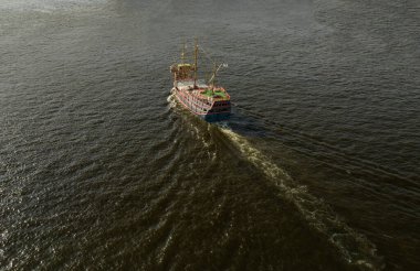 Eski tarz korsan gemisi güneşe doğru açık denizde yelkensiz yol alıyor. Yüksek kalite fotoğraf
