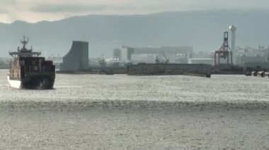 Slide past fully loaded container ship entering industrial harbor. High quality 4k footage