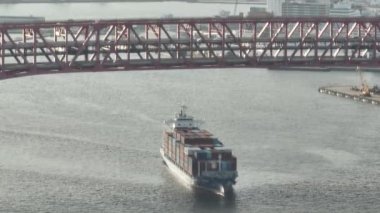 Overhead view of container ship under bridge with steady traffic. High quality 4k footage