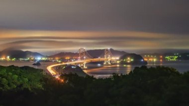 Gece vakti trafik ve sis, asma köprüden geçiyor. Yüksek kalite 4k görüntü