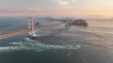 Gün batımında Naruto asma köprüsünün altındaki girdap ve anaforların üzerinden hava harekatı. Yüksek kalite 4k görüntü