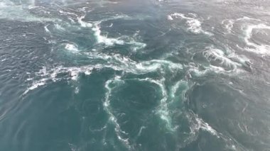 Powerful current forms small whirlpools and eddies in ocean water. High quality 4k footage