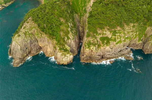 Aerial view of sheer cliffs and wave-cut canyon on rocky coastline. High quality photo