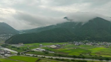 Hyperlapse: Morning fog on mountain over green rice fields and country town in valley. High quality 4k footage