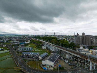Shinkansen, fırtına bulutlarının altındaki yerleşim alanındaki yüksek raylarda. Yüksek kalite fotoğraf