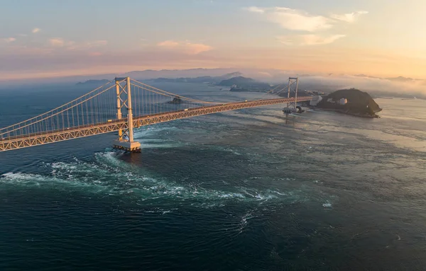 Aerial view of strong current under Naruto bridge at sunset. High quality photo