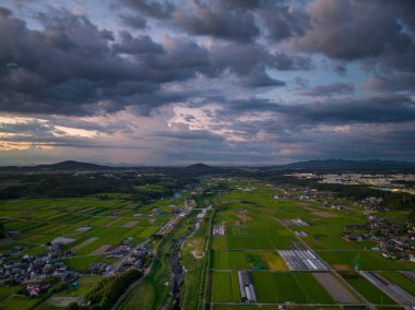 Gün batımında çiftliklerin ve kırsal alanların üzerinde dramatik bulutlar. Yüksek kalite fotoğraf