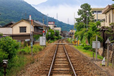 Railroad track through small Japanese mountain town as morning fog clears. High quality photo
