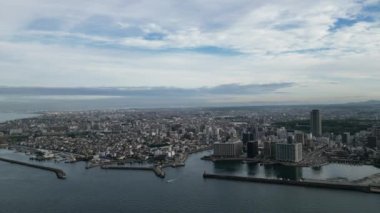 Flying over water towards harbor entrance and central Akashi City. High quality 4k footage