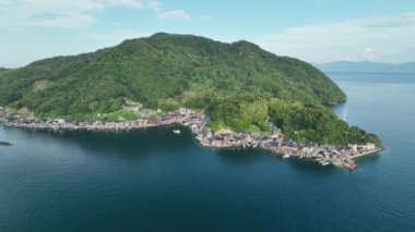 Descend down to sea level in small fishing town on mountain peninsula . High quality 4k footage