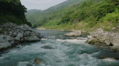 Slow motion move over small rapid in river through mountain gorge . High quality 4k footage
