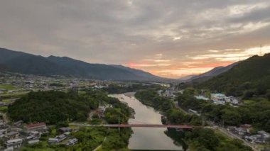 Hyperlapse: Sunrise over river through valley and rural towns in mountain landscape. High quality 4k footage