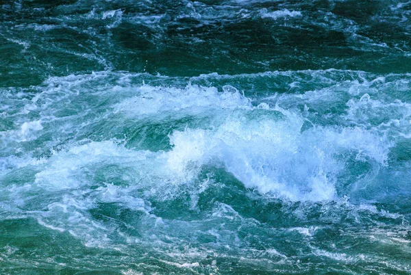 Turbulent turquoise water and white waves in strong current. High quality photo