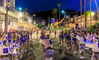 Performers dance in street as night falls on traditional Japanese festival. High quality photo