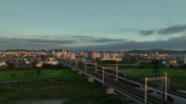 Trains pass in opposite directions in front of Himeji City skyline at dawn. High quality 4k footage