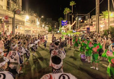 Tokushima, Japan - August 12, 2022: Performers parade down street during crowded Awaodori festival. High quality photo