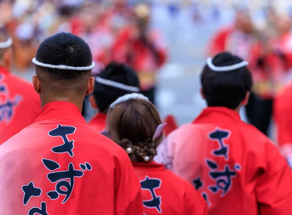Tokushima, Japan - August 12, 2022: Performers in bright red traditional clothing and headbands at Japanese summer festival. High quality photo
