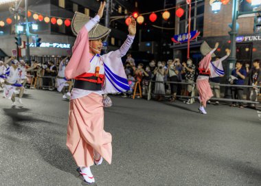 Tokushima, Japan - August 12, 2022: Woman wearing pink kimono performs at Japanese street festival. High quality photo
