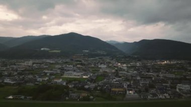 Pullback on small town and misty mountains as night falls. High quality 4k footage