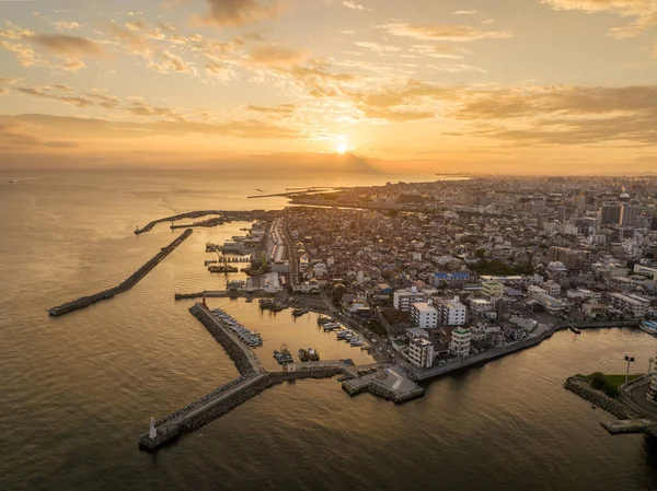 Aerial view of breakwaters at small harbor on coastal town at sunset. High quality photo