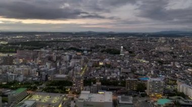 Hyperlapse: Moving over buildings and traffic in small city as night falls. High quality 4k footage