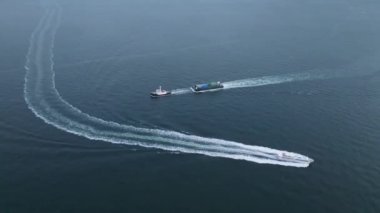 High-speed ferry passing slow tug and barge in calm open water. High quality 4k footage