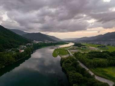 River flows through rural valley and small towns after sunset. High quality photo