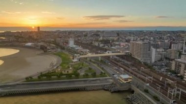 Hyperlapse: Sunsets over road and train tracks along coastal small city. High quality 4k footage