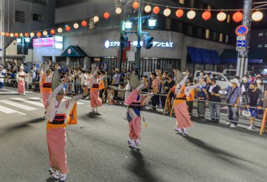 Tokushima, Japan - August 12, 2022: Dancers wearing pink kimonos perform at Japanese street festival. High quality photo