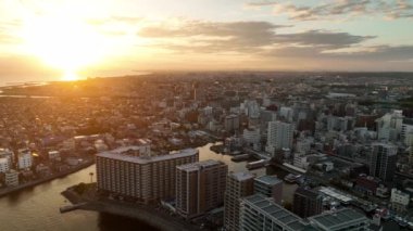Aerial view of tall apartment buildings and downtown harbor at sunset. High quality 4k footage
