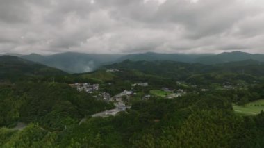 Rotating around small mountain village as dark rain clouds move in. High quality 4k footage