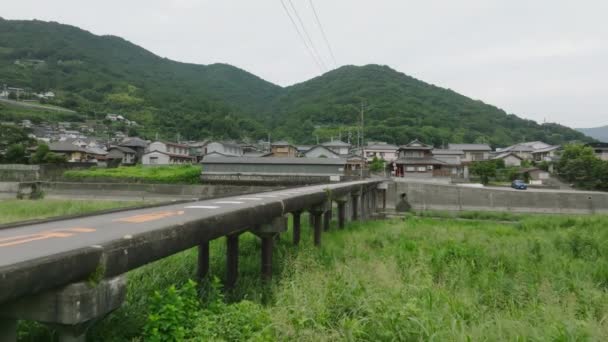 Narrow Bridge Railing Leads Small Town Foot Green Mountain High — Stockvideo