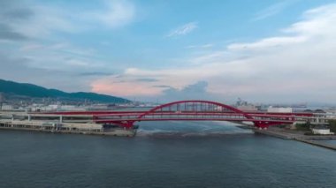 Hyperlapse: Cars move over red arched bridge next to ferry terminal. High quality 4k footage