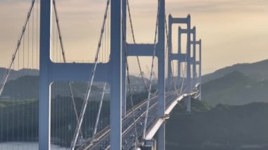 Light traffic over iconic Kurushima Kaikyo Bridge along the Shimanami Kaido at sunset. High quality 4k footage