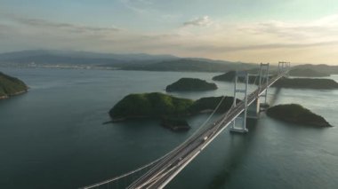 Aerial view of long suspension bridge through small islands toward Imabari. High quality 4k footage