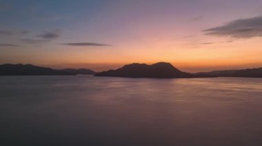 Hyperlapse: Pre-dawn color fades over small mountain island on remote coast. High quality 4k footage
