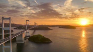 Hyperlapse: Sun sets next to long suspension bridge between small islands. High quality 4k footage