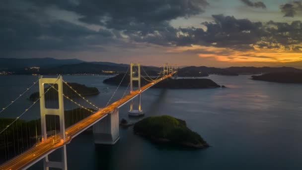 ハイパーラプス 日没の輝きの長い吊り橋に沿って移動する交通からの光 高品質4K映像 — ストック動画