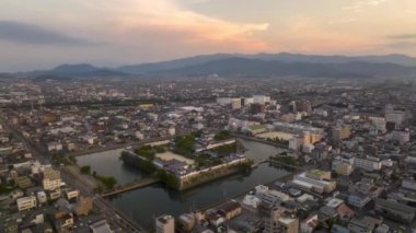 Işık hızı: İmabari Kalesi ve genişleyen şehir aydınlandıkça gün geceye dönüşür. Yüksek kalite 4k görüntü