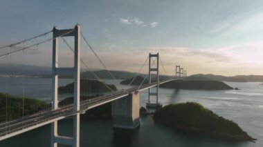 Gün batımında Kurushima Köprüsü 'nde küçük adalar arasında hafif trafiğin üzerinde yükseliyor. Yüksek kalite 4k görüntü