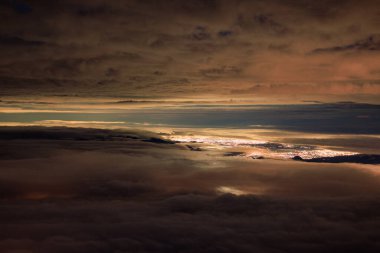 Bulut katmanları uzak şehrin ışıklarını kırıyor. Yüksek kalite fotoğraf
