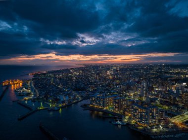 Akşamın erken saatlerinde deniz kıyısındaki dairelerin üzerinde dramatik bir gökyüzü. Yüksek kalite fotoğraf