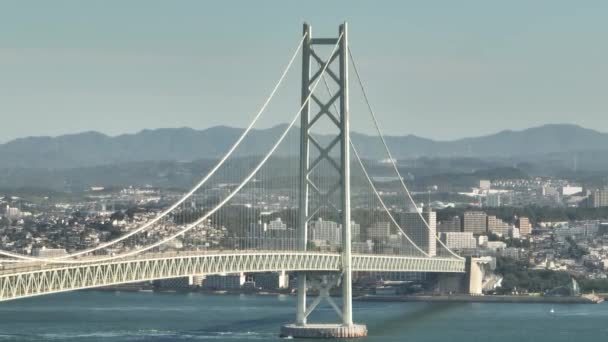 Tower Suspension Bridge Rises Coastal Town Distant Mountains High Quality — Stock Video