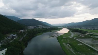 Dağlara rağmen üstgeçit nehri ve alacakaranlıkta kırsal alan. Yüksek kalite 4k görüntü