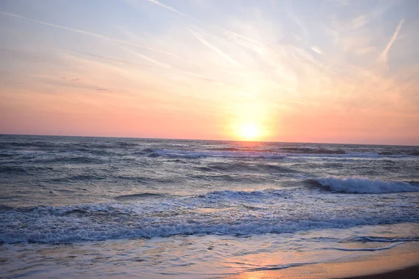 Ένα Όμορφο Ηλιοβασίλεμα Στην Παραλία Στον Ταραγμένο Ωκεανό Αποχρώσεις Πορτοκαλί — Φωτογραφία Αρχείου